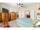 Well-lit bedroom with ceiling fan, large dresser, and convenient access to the Primary bathroom, ideal for comfort at 7333 Sw 98Th Ct, Ocala, FL 34481