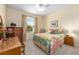 Cozy bedroom with a bright window, floral bedding, and classic wooden furniture, ideal for relaxation at 7333 Sw 98Th Ct, Ocala, FL 34481