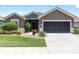 Charming home exterior with a manicured lawn and a two-car garage, great curb appeal and design at 7333 Sw 98Th Ct, Ocala, FL 34481
