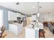 Modern kitchen with stainless steel appliances, white cabinets, and marble countertops open to dining and living spaces at 7333 Sw 98Th Ct, Ocala, FL 34481