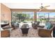Relaxing screened-in lanai featuring comfortable wicker furniture, a ceiling fan, and views of the green backyard at 7333 Sw 98Th Ct, Ocala, FL 34481
