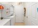 Efficient laundry room featuring a stacked washer/dryer, counter space, storage shelves, and convenient access to the outside at 7333 Sw 98Th Ct, Ocala, FL 34481