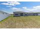 Wide backyard featuring healthy grass, a white fence, and a view of the rear facade at 7571 Sw 64Th Street Rd, Ocala, FL 34474
