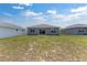 Wide backyard featuring healthy grass, a white fence, and a view of the rear facade at 7571 Sw 64Th Street Rd, Ocala, FL 34474