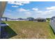 Spacious backyard with green grass surrounded by a white fence, offering ample space and privacy at 7571 Sw 64Th Street Rd, Ocala, FL 34474