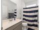 Bathroom featuring vanity with quartz countertops and shower with blue striped curtain at 7571 Sw 64Th Street Rd, Ocala, FL 34474