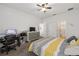Bright bedroom with neutral carpeting, a ceiling fan, a dresser, and a nearby bathroom at 7571 Sw 64Th Street Rd, Ocala, FL 34474
