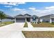 Attractive single-story home with gray siding, a two-car garage, and a manicured lawn at 7571 Sw 64Th Street Rd, Ocala, FL 34474