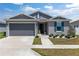 Charming single-story home with a gray exterior, blue shutters, and a well-manicured front yard at 7571 Sw 64Th Street Rd, Ocala, FL 34474