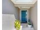 Inviting covered front porch with a blue front door and decorative plants at 7571 Sw 64Th Street Rd, Ocala, FL 34474