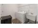Functional laundry room featuring a washer, dryer, sink, and wire shelving at 7571 Sw 64Th Street Rd, Ocala, FL 34474