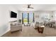 Bright living room features neutral tones, TV, ceiling fan, and sliding glass door to the yard at 7571 Sw 64Th Street Rd, Ocala, FL 34474