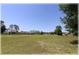 Spacious backyard view with lush green grass and beautiful homes in the distance at 96 Hickory Crse, Ocala, FL 34472