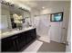 Bathroom with dual sinks, vanity, shower, and decorative curtains at 96 Hickory Crse, Ocala, FL 34472