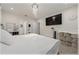 Bright bedroom featuring neutral decor, an ensuite bathroom, a mounted television, and storage solutions at 96 Hickory Crse, Ocala, FL 34472