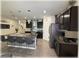 Open-concept kitchen with dark cabinets, stainless steel appliances, an island with seating, and stylish decor at 96 Hickory Crse, Ocala, FL 34472