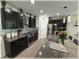 Well-equipped kitchen with dark cabinets, stainless steel appliances, granite countertops, and a mosaic backsplash at 96 Hickory Crse, Ocala, FL 34472