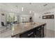 Kitchen island with breakfast bar, granite countertops, stainless steel appliances and dark cabinets at 96 Hickory Crse, Ocala, FL 34472