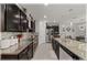 Open-concept kitchen features granite countertops, dark cabinets and stainless steel appliances at 96 Hickory Crse, Ocala, FL 34472