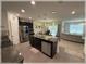 Contemporary kitchen with stainless steel appliances, a granite countertop island, and a view into the living area at 96 Hickory Crse, Ocala, FL 34472