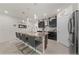 Kitchen island with breakfast bar, granite countertops, stainless steel appliances and dark cabinets at 96 Hickory Crse, Ocala, FL 34472