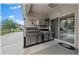 An outdoor kitchen boasts stainless steel appliances beneath a covered patio at 96 Hickory Crse, Ocala, FL 34472