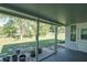 Covered porch overlooking a large yard features small rocks, potted plants, and a partial view of the grass at 10523 Sw 62Nd Terrace Rd, Ocala, FL 34476