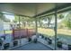 Spacious screened porch with views of a deck, large lawn, and scattered trees, enhanced with white rock accents at 10523 Sw 62Nd Terrace Rd, Ocala, FL 34476