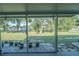 Enclosed porch with views of a large grassy backyard with scattered trees and white rock accents at 10523 Sw 62Nd Terrace Rd, Ocala, FL 34476