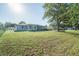Large, well-maintained backyard featuring a lush green lawn, mature trees, and a deck at 10523 Sw 62Nd Terrace Rd, Ocala, FL 34476