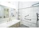 Bright bathroom featuring a sleek vanity, mirror and stylish walk-in shower with grab bars and tiled walls at 10523 Sw 62Nd Terrace Rd, Ocala, FL 34476