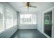Cozy sunroom features many windows with white blinds, ceiling fan, and gray flooring at 10523 Sw 62Nd Terrace Rd, Ocala, FL 34476