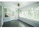 Relaxing sunroom with large windows, white blinds, and gray painted concrete flooring at 10523 Sw 62Nd Terrace Rd, Ocala, FL 34476