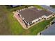 Aerial view showing the home's manicured landscaping, decorative stone features, and a sunny, glass-enclosed back patio at 11871 Se 91St Cir, Summerfield, FL 34491