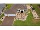 Aerial view of a well-manicured single Gathering home featuring lush landscaping, a spacious lawn, and a paved driveway at 11871 Se 91St Cir, Summerfield, FL 34491