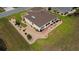 An overhead view features a charming home surrounded by meticulously maintained garden beds and a sunny enclosed patio at 11871 Se 91St Cir, Summerfield, FL 34491
