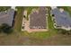 Aerial shot of a meticulously landscaped property featuring lush green lawns, a brick-lined patio, and a brown roof at 11871 Se 91St Cir, Summerfield, FL 34491