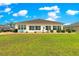 View of the home's back exterior highlighting the lawn and windows at 11871 Se 91St Cir, Summerfield, FL 34491
