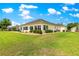 A well maintained home backyard featuring a large glassed-in sunroom and well-kept landscaping at 11871 Se 91St Cir, Summerfield, FL 34491