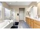 This bathroom features double sinks, wooden cabinets, and a glass-enclosed shower and bathtub at 11871 Se 91St Cir, Summerfield, FL 34491