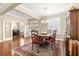 Formal dining room features hardwood floors, wainscoting, plantation shutters, and a chandelier at 11871 Se 91St Cir, Summerfield, FL 34491