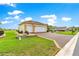 Attached two-car garage with paved driveway, complemented by manicured landscaping and green lawns at 11871 Se 91St Cir, Summerfield, FL 34491