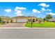 Inviting exterior featuring a three car garage and well maintained landscape at 11871 Se 91St Cir, Summerfield, FL 34491