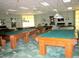 Spacious game room featuring multiple pool tables under bright lighting, perfect for entertainment at 11871 Se 91St Cir, Summerfield, FL 34491