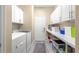 Functional laundry room with front-loading washer, dryer, and ample storage at 11871 Se 91St Cir, Summerfield, FL 34491