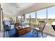 This sunroom features comfortable seating, lots of windows, and views of the golf course at 11871 Se 91St Cir, Summerfield, FL 34491