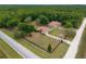 Expansive property featuring a house, garage, pool, and black-fenced yard, all set against a backdrop of lush green forest at 12495 Sw 66Th St, Ocala, FL 34481