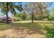 Picturesque backyard with mature trees, lush lawn, and a screened porch visible at 12495 Sw 66Th St, Ocala, FL 34481