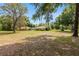 Large backyard with a well-maintained lawn, mature trees, and the house in the background at 12495 Sw 66Th St, Ocala, FL 34481