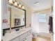 Bathroom featuring a shower-tub combo, white vanity, and a big mirror with great lighting at 12495 Sw 66Th St, Ocala, FL 34481
